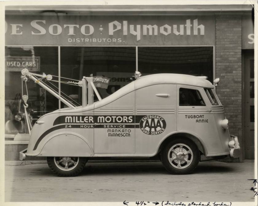 1937 International Harvester cab-over-engine (COE) tow truck parked in front of Miller Motors dealership.