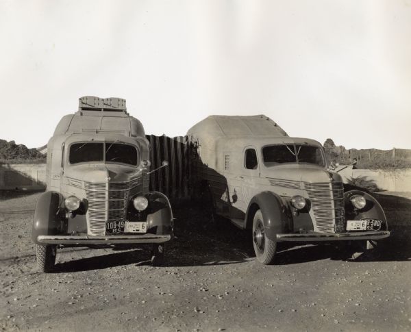 1937 Two specially designed International trucks connected with an awning at an African camp site