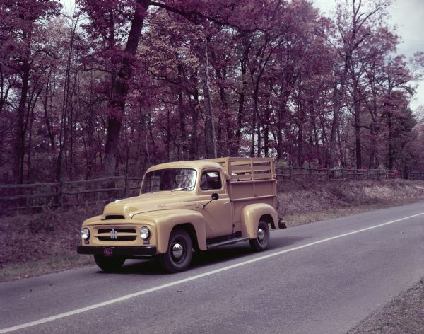 1953 International Harvester standard model R-110 truck with a pickup body and ADA-RAK travels down a wooded roa