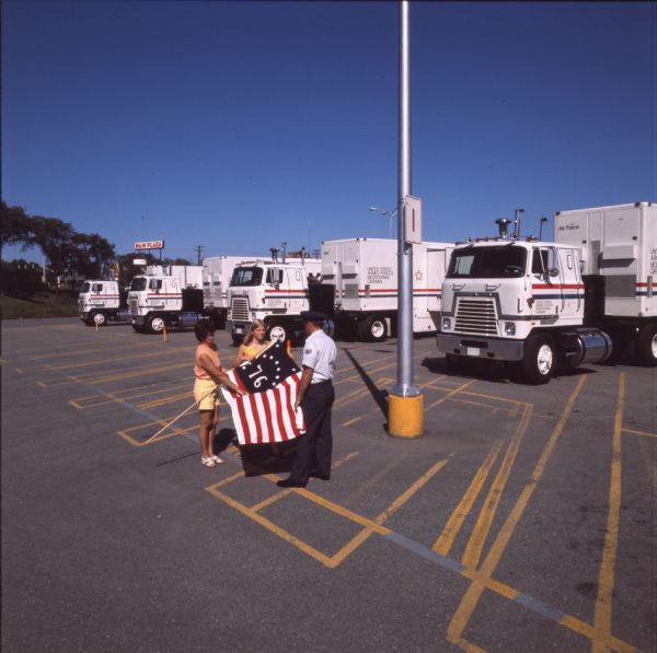 1976 International Woman, Young Woman, and Man with '76 Flag and Trucks